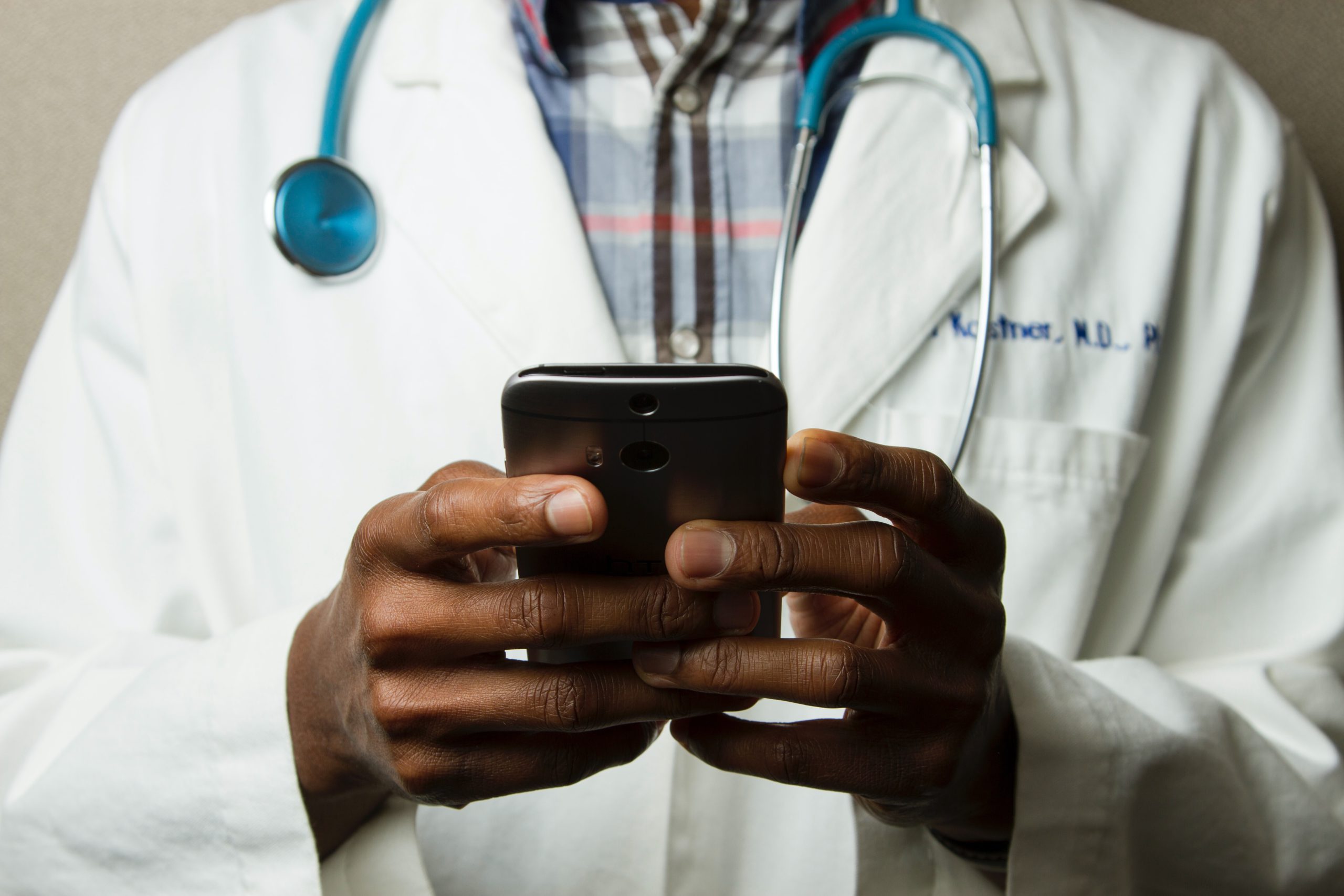 Doctor sending a text message about the staffing shortages he has been having