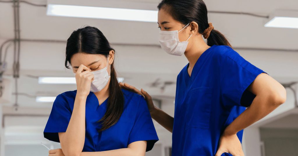 Nurse conforting a coworker experiencing burnout